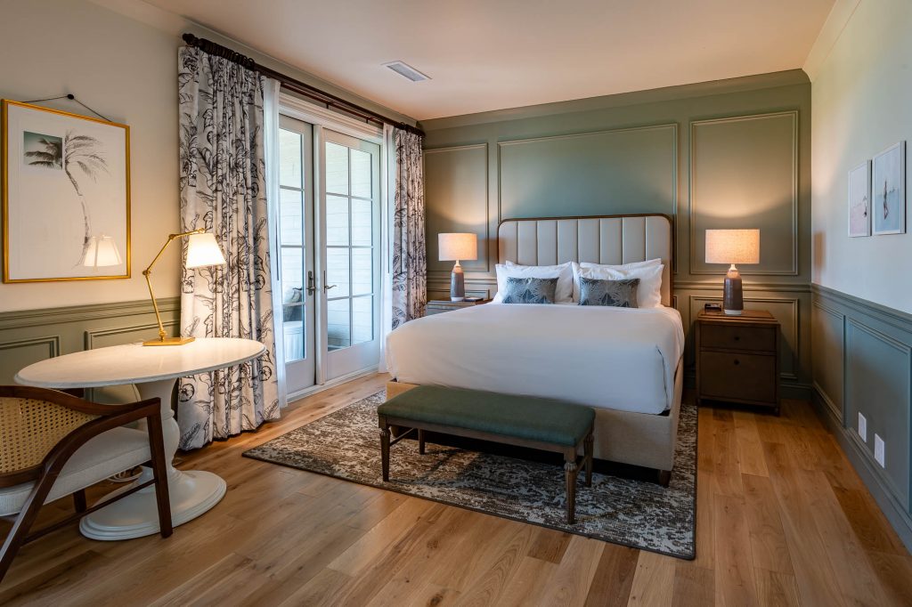 king-sized bed against green accent wall featured in the Pine Suite