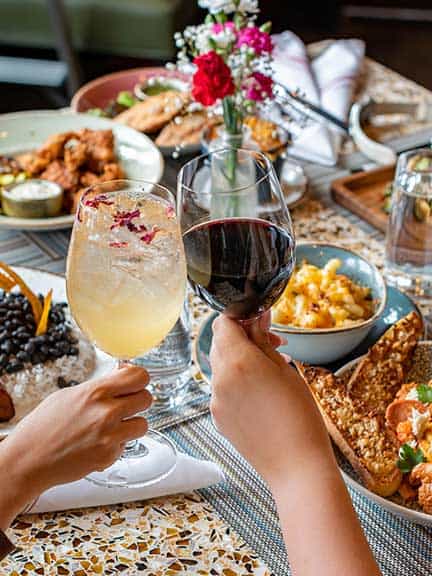 Having a toast over a table full of food.