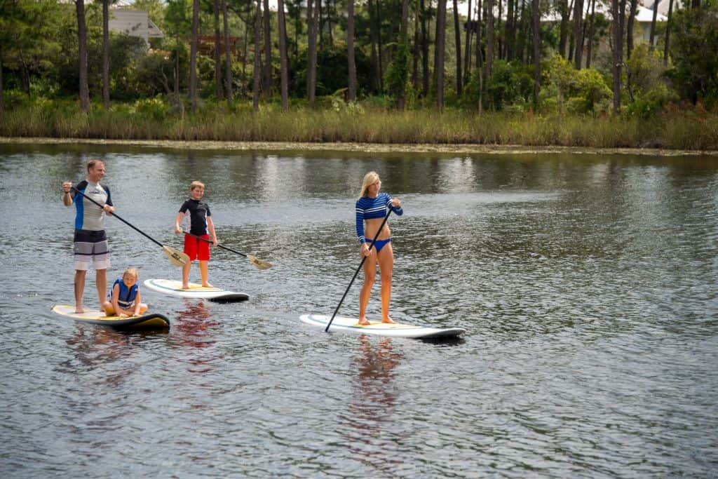 Family on standup paddleboards in the water.