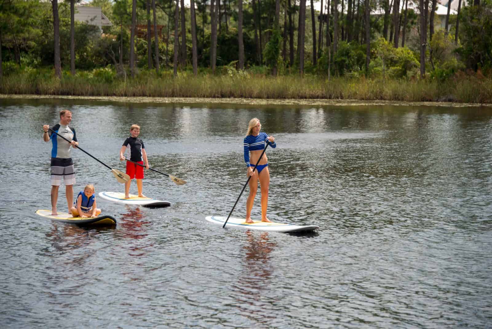 Family on standup paddleboards in the water.