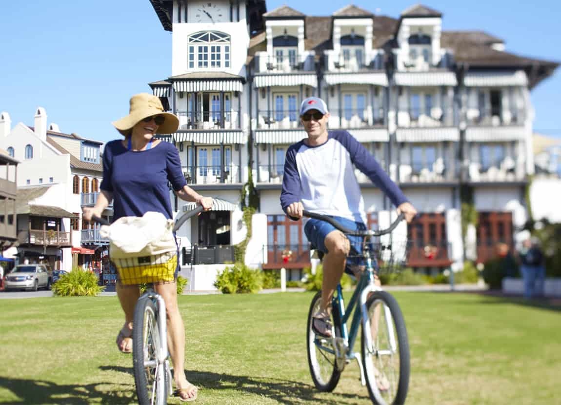 A couple riding bikes behind The Pearl Hotel.