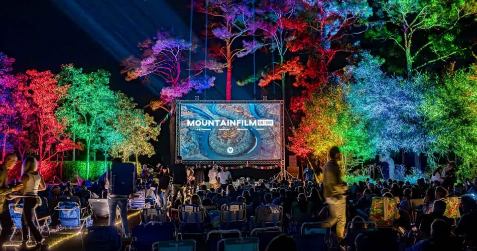Colored lights illuminate the trees of WaterColor® Marina Park at an outdoor film screening during MountainFilm on Tour.